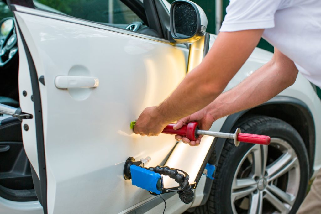 Débosselage sans peinture sur une carrosserie blanche avec outils PDR